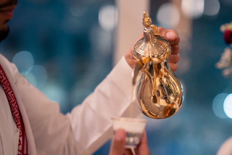 Traditional Saudi coffee pouring from a golden Dallah