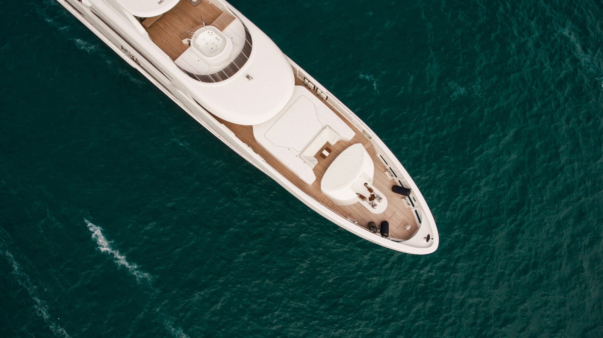 Aerial view of a luxury superyacht cruising through deep emerald Red Sea waters