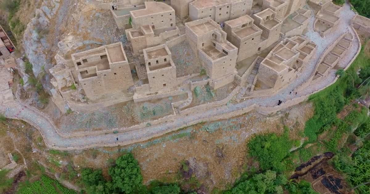 Aerial view of traditional Saudi Arabian heritage villages with stone buildings, winding pathways, and mountain backdrop