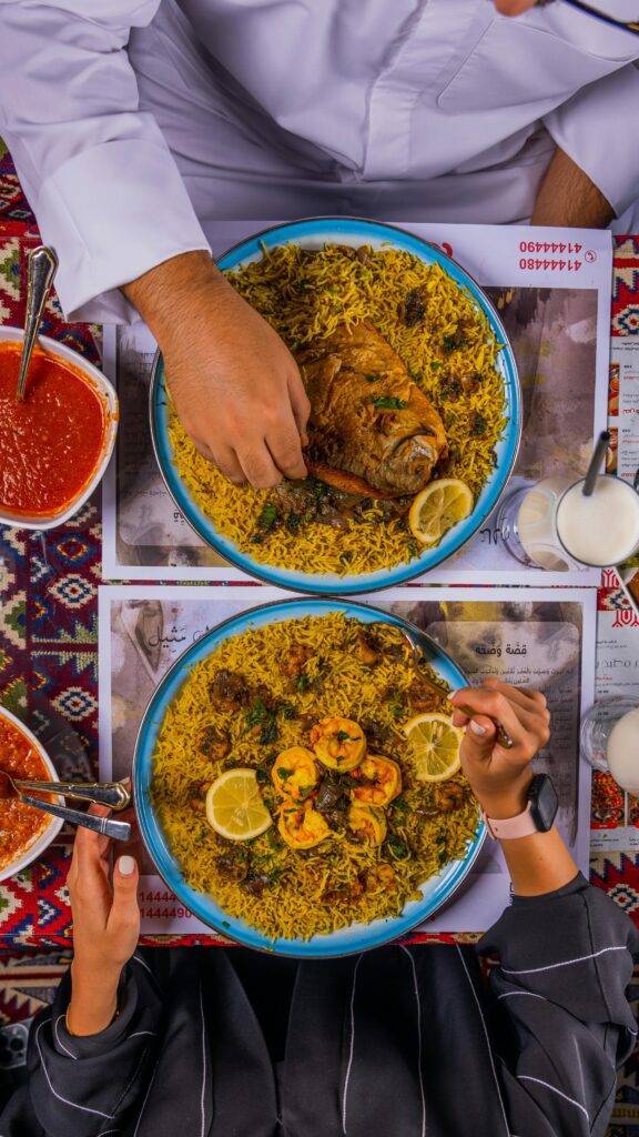 A delicious top view of traditional Middle Eastern Kabsa and Mandi rice dishes served with rich flavors.