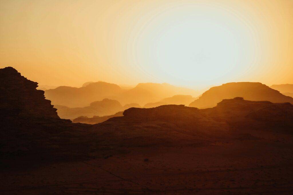 Beautiful sunset over the desert in Aqaba Governorate, Jordan, showcasing stunning silhouettes and golden hues.