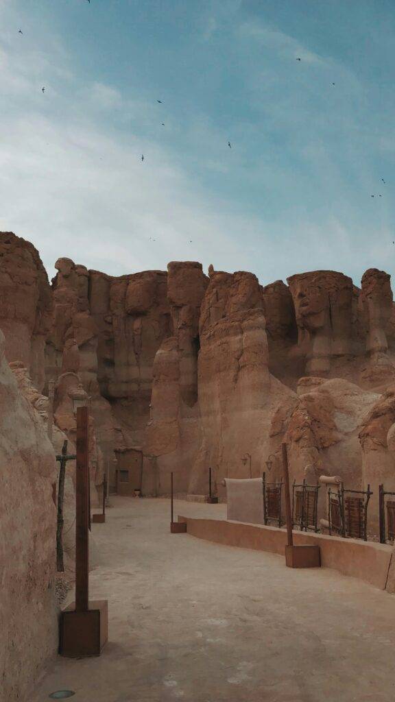 Explore the stunning rocky formations of Al-Qarah Mountain, Saudi Arabia, under a summer sky.