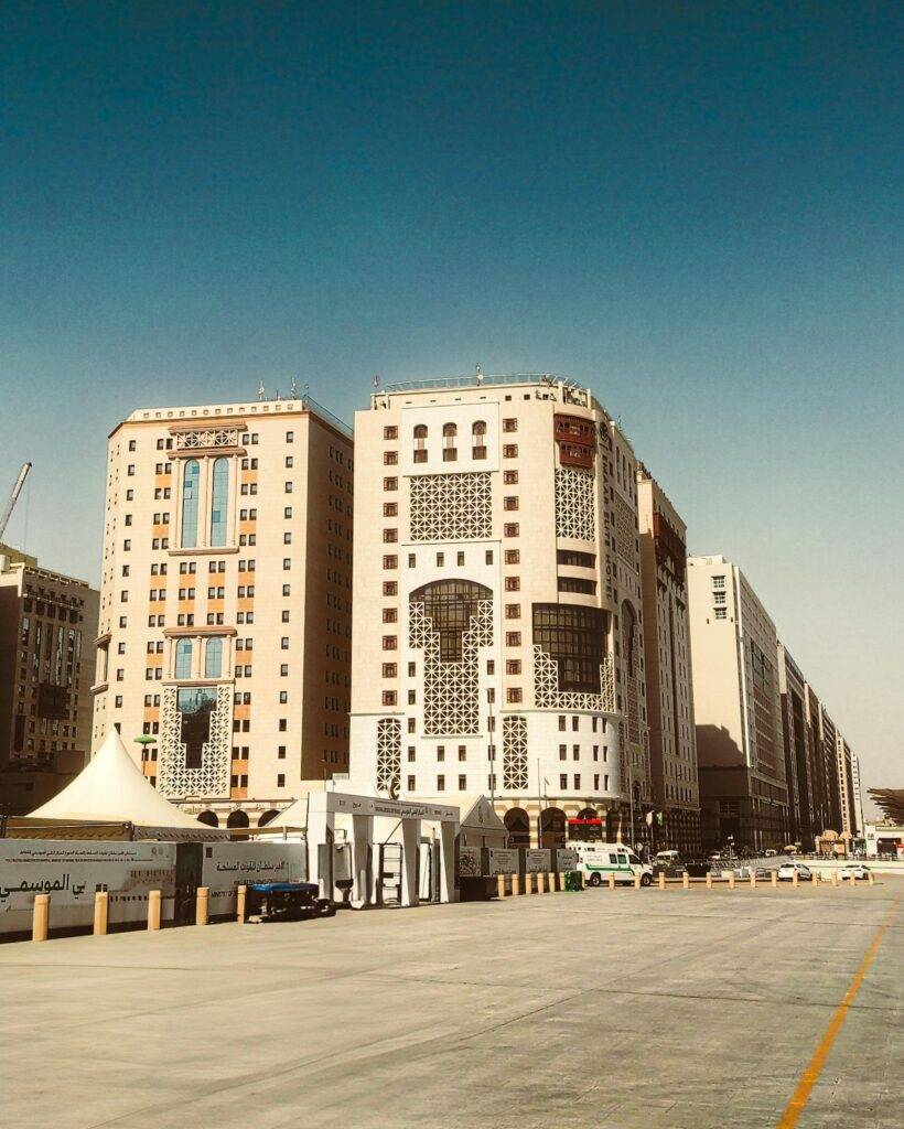 Contemporary buildings in Madinah, Saudi Arabia against a clear blue sky.