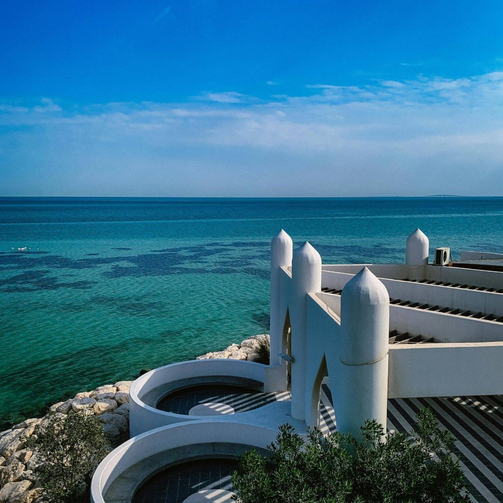 A stunning view of Al Khobar's coastal architecture against a bright blue sea and sky.