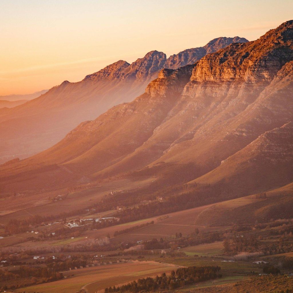 Breathtaking view of Stellenbosch mountains and valleys at sunrise, capturing nature's beauty.
